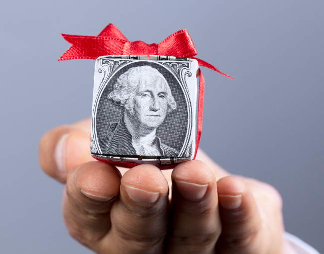 small gift parcel of money extended by a hand