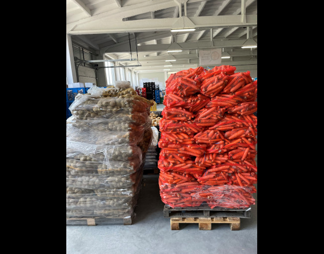 pallets stacked with bags of carrots and potatoes